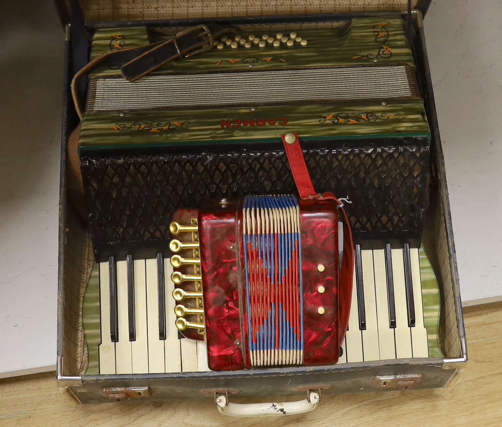 A cased Carmen piano accordion and another smaller keyed accordion (2)